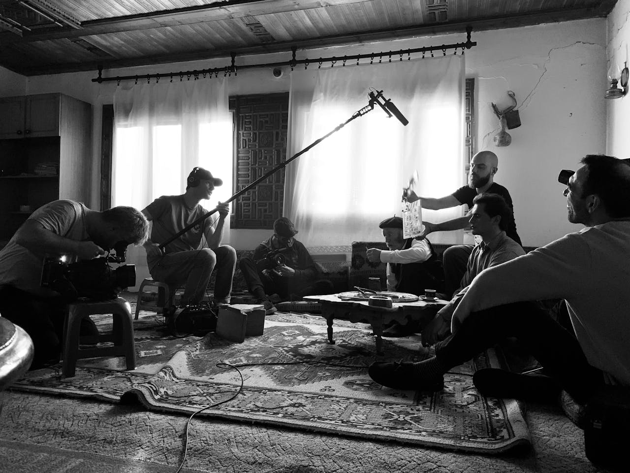 Film crew working indoors on a video shoot, capturing behind-the-scenes action.
